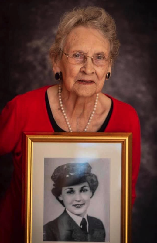 Joan Jones holding a picture of herself in uniform
