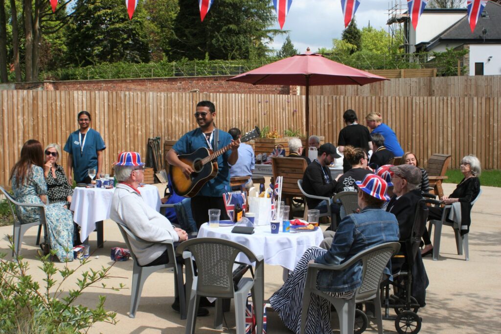Broughton House staff performing the guitar for residents families in the garden